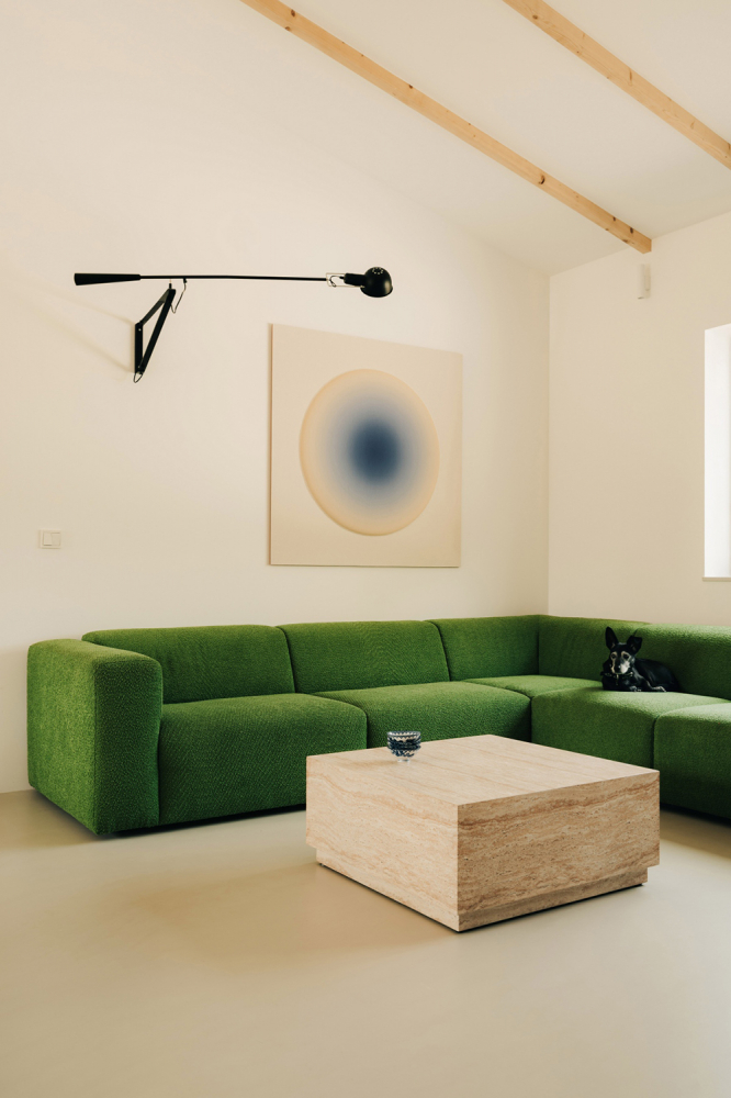 Тёплый современный интерьер с зелёным диваном в Познани
